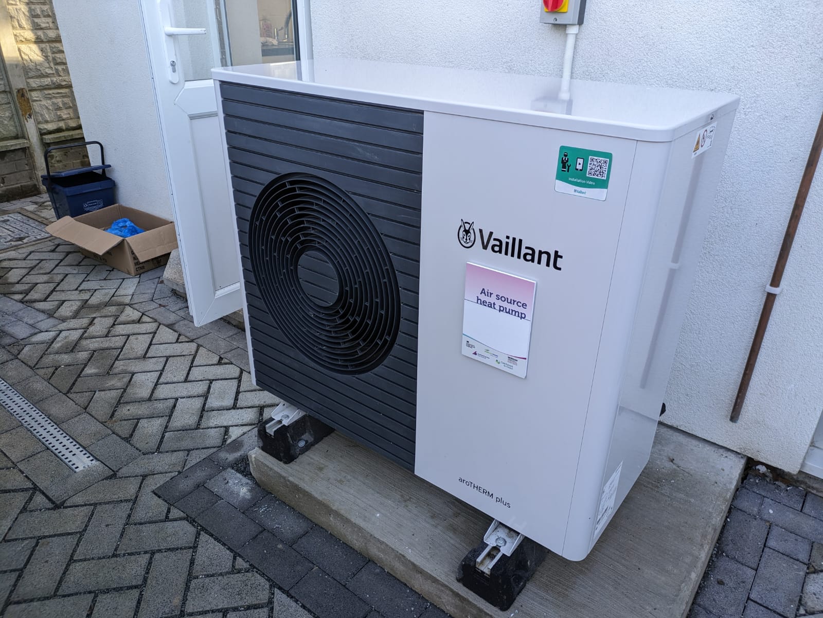 An outdoor heat-pump unit installed against the side of a US single-family home.