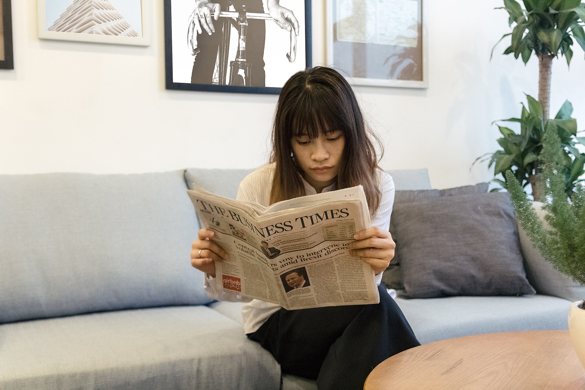 A reader scanning multiple technology news sources on a laptop and printed magazine.